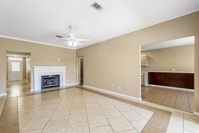 unfurnished living room with ceiling fan, a fireplace, light tile patterned floors, and ornamental molding