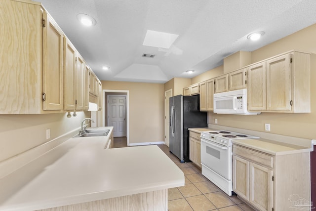 kitchen featuring white appliances, sink, light brown cabinetry, and a skylight