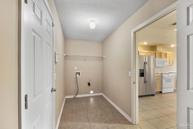 laundry area with hookup for a washing machine, tile patterned flooring, a textured ceiling, and hookup for an electric dryer