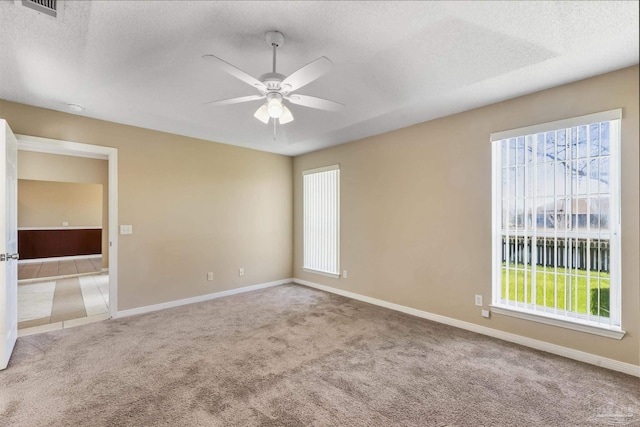 unfurnished room featuring a textured ceiling, light colored carpet, and ceiling fan