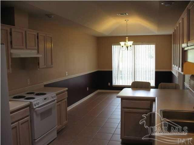 kitchen featuring a chandelier, pendant lighting, white appliances, and tile patterned flooring