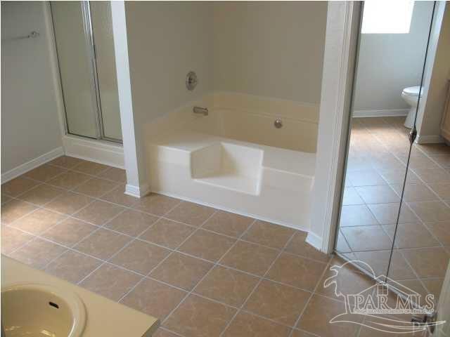 bathroom featuring toilet, separate shower and tub, and tile patterned floors