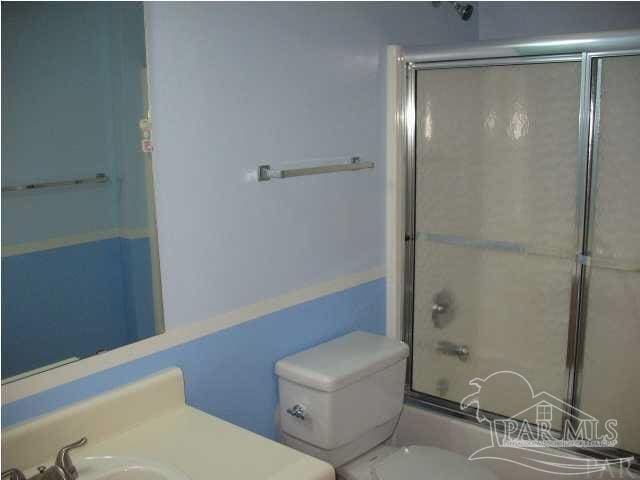 full bathroom featuring vanity, toilet, and shower / bath combination with glass door