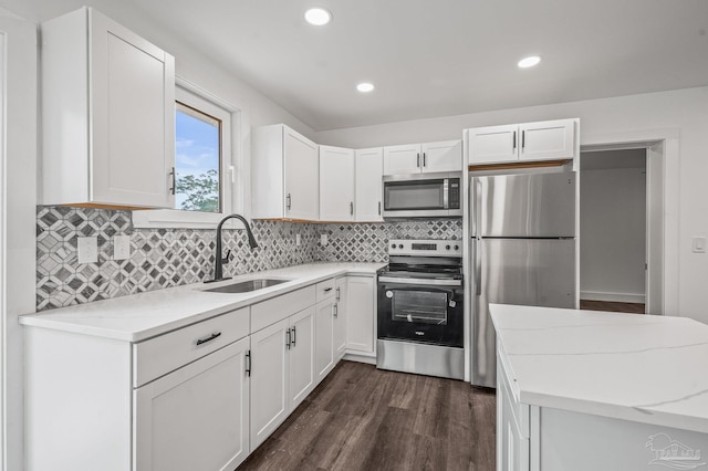 4732 Pine Ln, Pace, FL 32571 - kitchen with appliances with stainless steel finishes, white cabinetry, backsplash, dark wood-style flooring, and recessed lighting