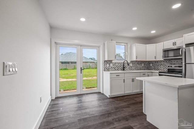 4732 Pine Ln, Pace, FL 32571 - kitchen featuring appliances with stainless steel finishes, light countertops, decorative backsplash, white cabinetry, and dark wood finished floors