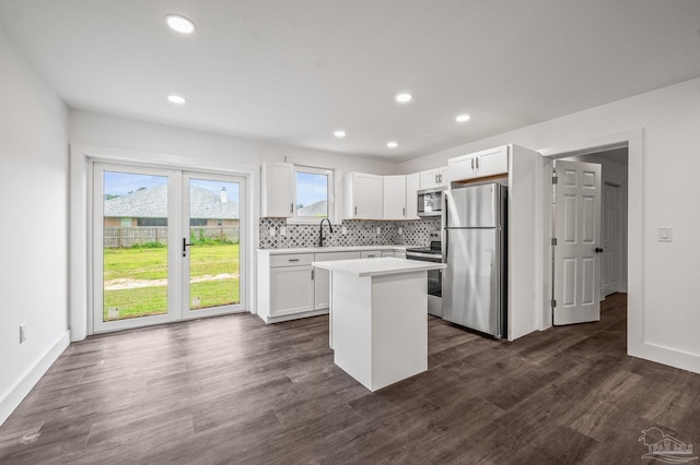 4732 Pine Ln, Pace, FL 32571 - kitchen with appliances with stainless steel finishes, light countertops, white cabinets, a kitchen island, and dark wood finished floors