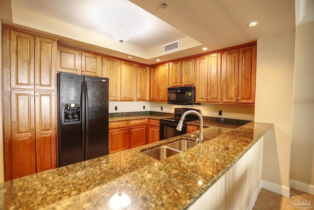 kitchen with sink, tile patterned floors, dark stone countertops, and black appliances