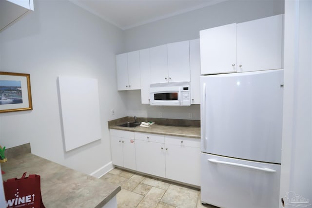 kitchen with stainless steel fridge, white cabinetry, and sink