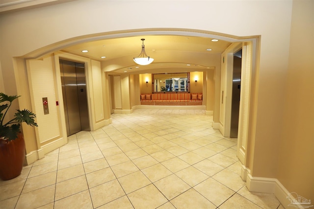 corridor with light tile patterned floors and elevator