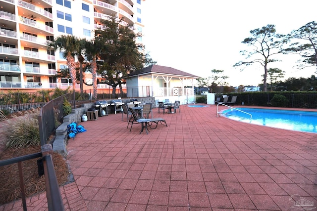 view of swimming pool with a patio area and a grill