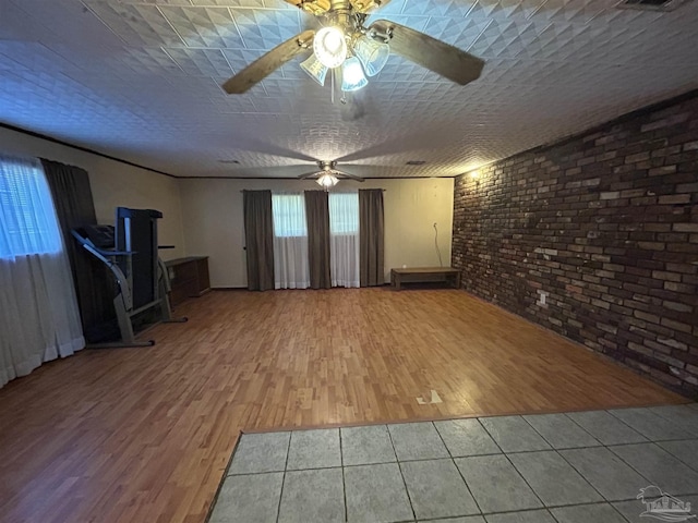 6232 Jalyn Rd, Pensacola, FL 32503 - unfurnished living room featuring a ceiling fan, tile patterned flooring, and brick wall