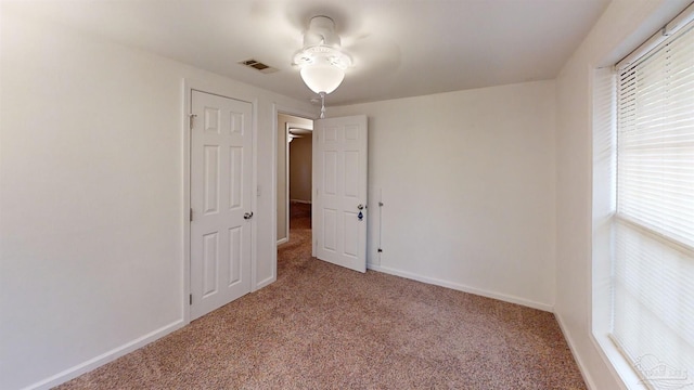 empty room with light carpet, ceiling fan, and plenty of natural light