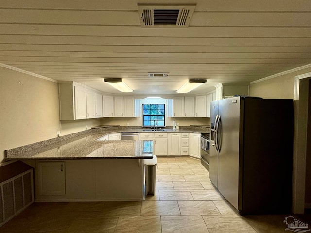 kitchen featuring stainless steel appliances, dark stone counters, white cabinetry, sink, and kitchen peninsula