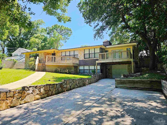 view of front of property with a front yard, a garage, and a wooden deck