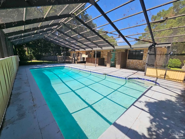 view of swimming pool with a patio area and a lanai