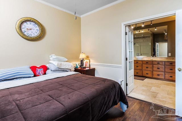 bedroom with light wood-type flooring, ensuite bathroom, ornamental molding, and sink