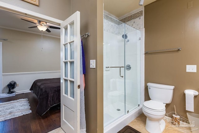 bathroom featuring ceiling fan, walk in shower, crown molding, hardwood / wood-style floors, and toilet