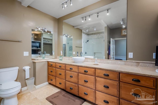 bathroom with vanity, a shower with door, track lighting, tile patterned floors, and toilet