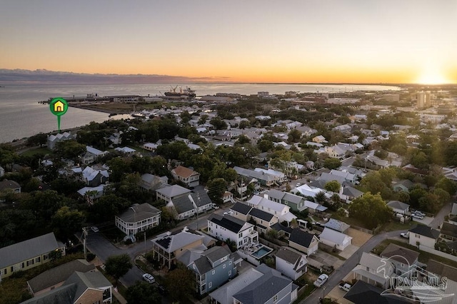 aerial view at dusk featuring a water view