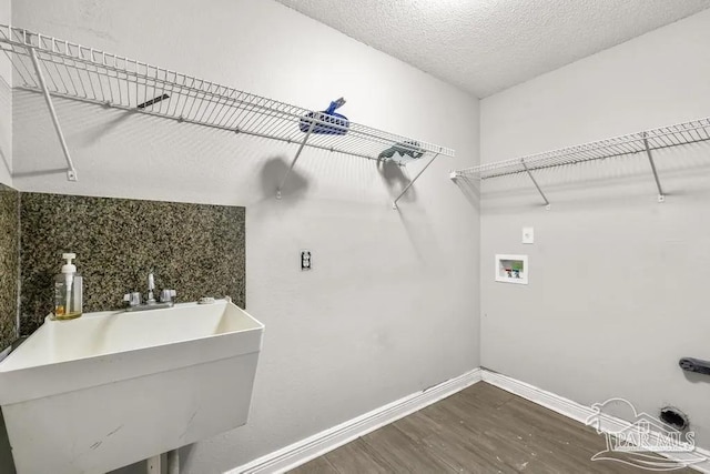 7210 Annandale Dr, Pensacola, FL 32526 - washroom with dark hardwood / wood-style flooring, hookup for a washing machine, a textured ceiling, and sink