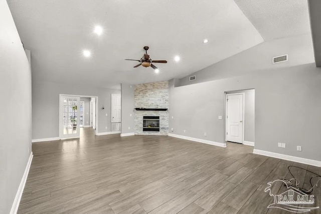 7210 Annandale Dr, Pensacola, FL 32526 - unfurnished living room with light wood-type flooring, vaulted ceiling, ceiling fan, and a stone fireplace