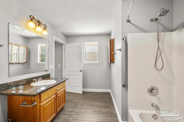 7210 Annandale Dr, Pensacola, FL 32526 - bathroom featuring  shower combination, vanity, a textured ceiling, and hardwood / wood-style flooring