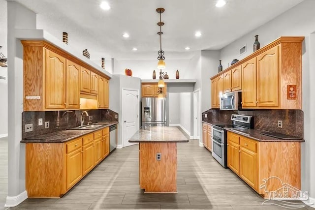 7210 Annandale Dr, Pensacola, FL 32526 - kitchen featuring a center island, stainless steel appliances, hanging light fixtures, and dark stone counters