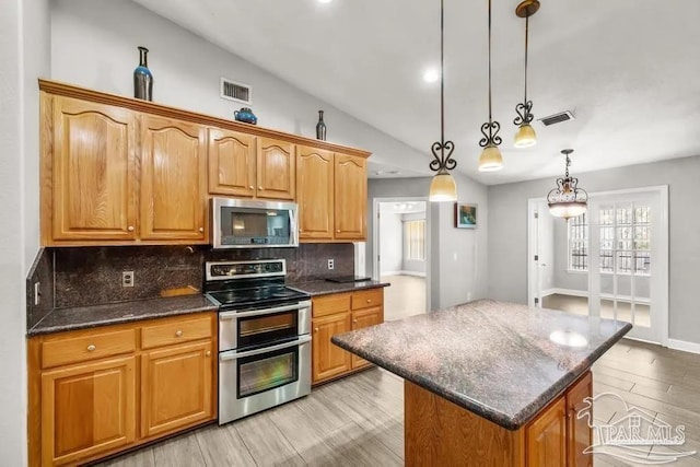 7210 Annandale Dr, Pensacola, FL 32526 - kitchen featuring a center island, stainless steel appliances, tasteful backsplash, pendant lighting, and lofted ceiling