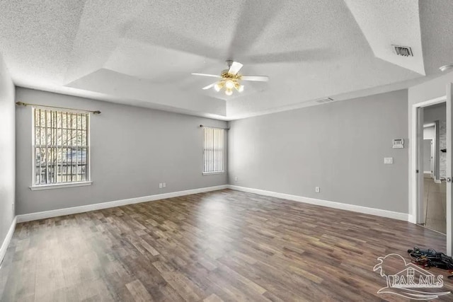 7210 Annandale Dr, Pensacola, FL 32526 - empty room featuring a textured ceiling, a wealth of natural light, and a tray ceiling