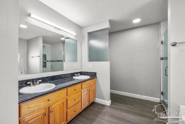 7210 Annandale Dr, Pensacola, FL 32526 - bathroom featuring vanity, wood-type flooring, a textured ceiling, and an enclosed shower