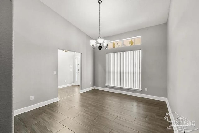 7210 Annandale Dr, Pensacola, FL 32526 - spare room featuring dark hardwood / wood-style flooring, high vaulted ceiling, and an inviting chandelier