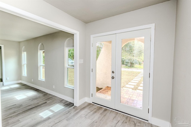 doorway to outside with light wood-style flooring, french doors, and a healthy amount of sunlight