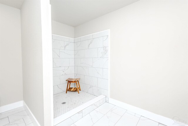 full bathroom featuring marble finish floor, a stall shower, and baseboards