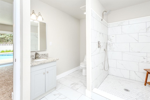 bathroom featuring baseboards, toilet, tiled shower, marble finish floor, and vanity