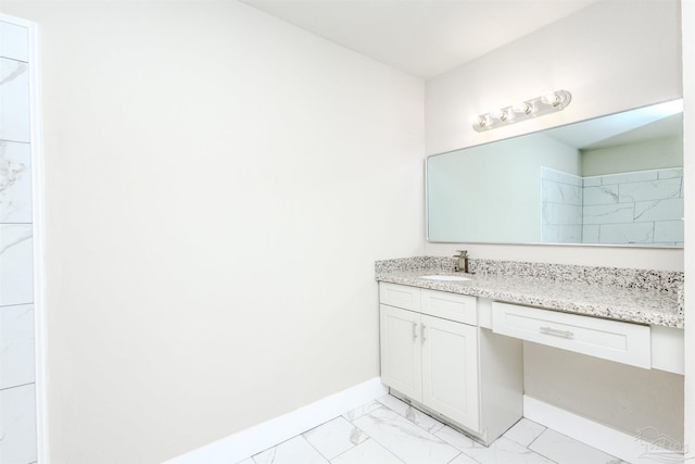 bathroom featuring marble finish floor, vanity, and baseboards