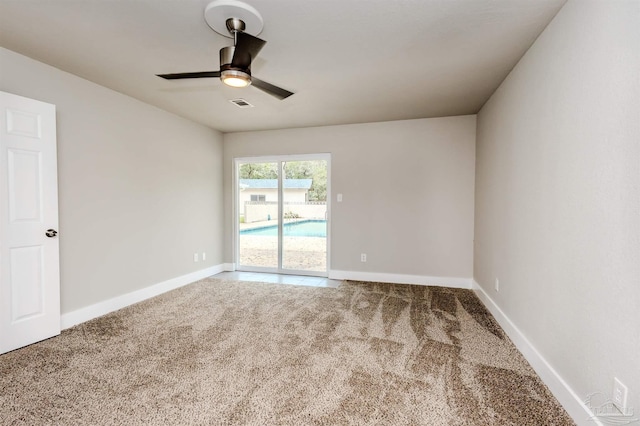 carpeted empty room with visible vents, baseboards, and a ceiling fan