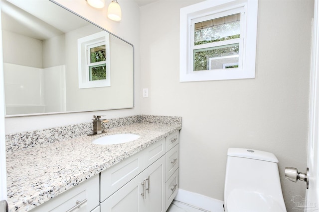 bathroom featuring vanity, toilet, baseboards, and marble finish floor