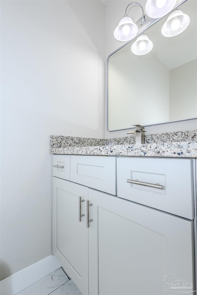 bathroom featuring baseboards, marble finish floor, and vanity