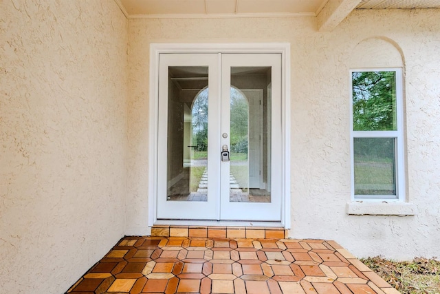 view of exterior entry with french doors and stucco siding