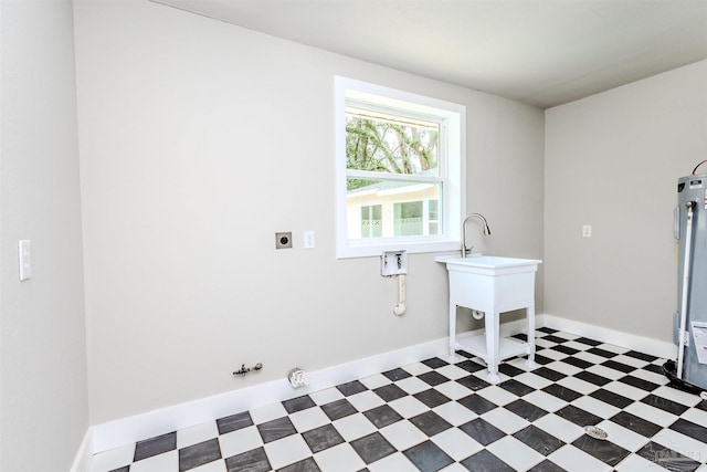 clothes washing area with laundry area, gas dryer hookup, baseboards, and tile patterned floors