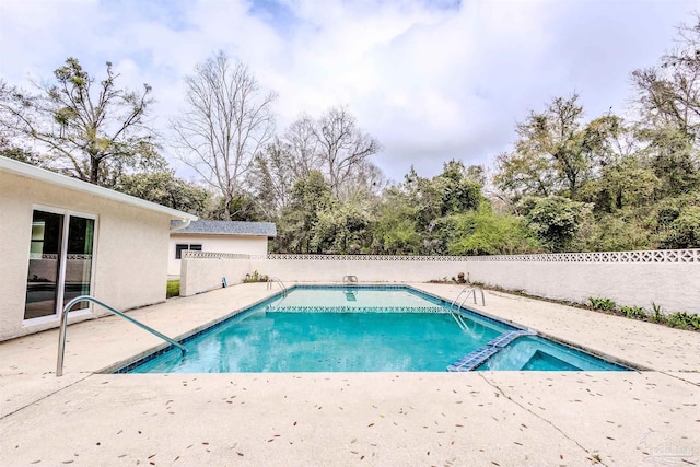 view of swimming pool with a patio area, fence, and a pool with connected hot tub