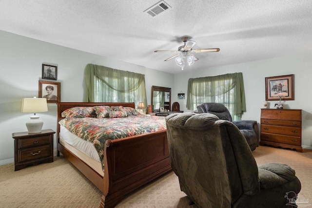 carpeted bedroom with ceiling fan and a textured ceiling