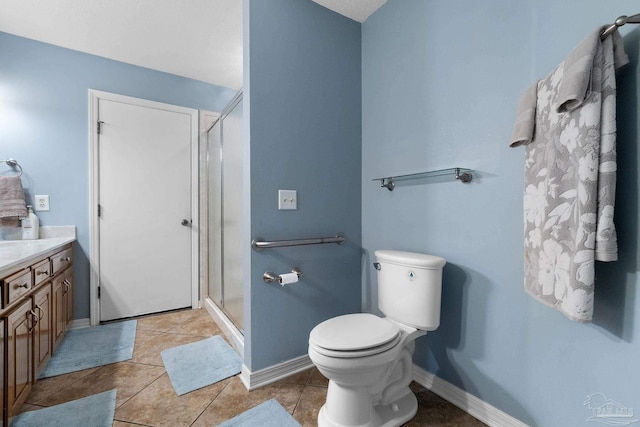 bathroom with vanity, toilet, a shower with shower door, and tile patterned flooring