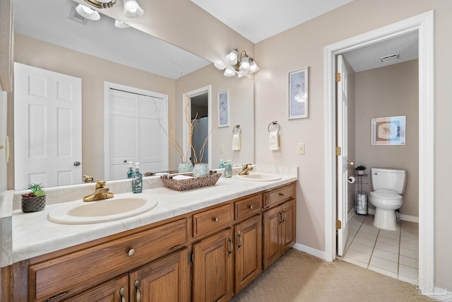 bathroom featuring toilet, vanity, and tile patterned floors