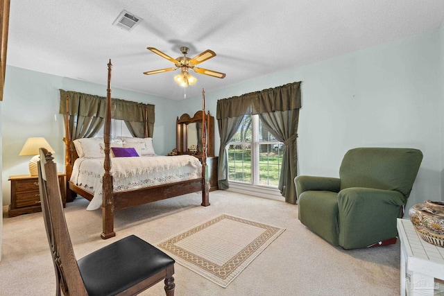 bedroom with light carpet, a textured ceiling, and ceiling fan