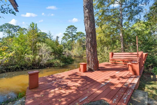 wooden deck with a dock and a water view