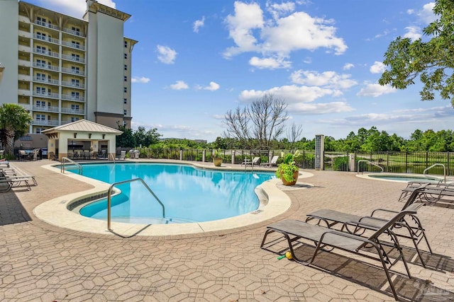 view of swimming pool with a hot tub and a patio