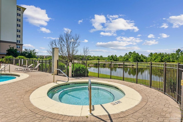 view of pool with a patio, a water view, and a community hot tub