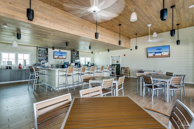 dining area featuring ceiling fan, dark hardwood / wood-style flooring, and wooden ceiling