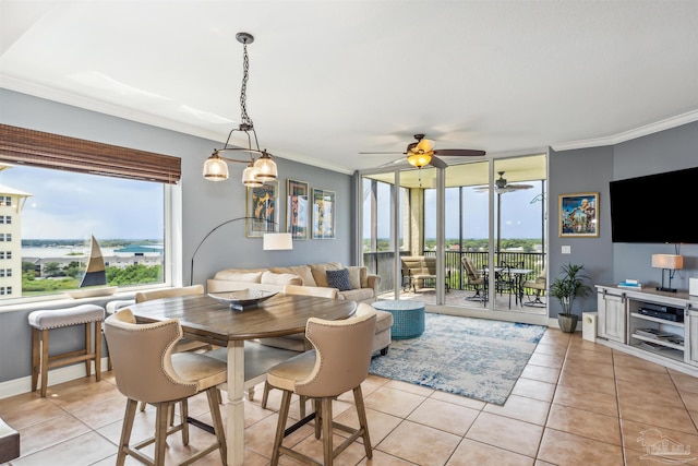 dining space with light tile patterned floors, crown molding, and a water view